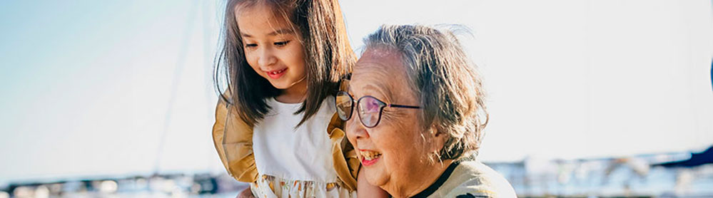 Uma senhora com descendência japonesa brinca com sua neta