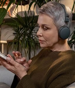 Uma jovem idosa ouve músicas ao celular