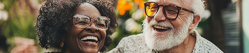 Um casal de 60+ se abraça sorrindo.