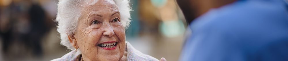 Senhora 60+ conversa animadamente com um jovem