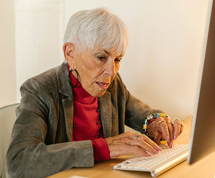 Uma senhora idosa trabalha no computador