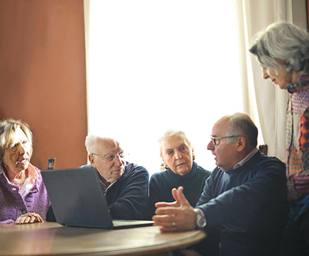 Cinco idosos estão discutindo temas importantes, com ar de preocupados