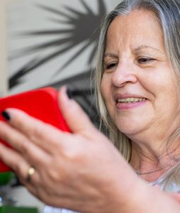 Uma senhora idosa está assistindo coisas pelo celular