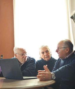 Cinco idosos estão discutindo temas importantes, com ar de preocupados